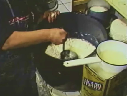 Teresa Campo removiendo la cuajada en un gran caldero durante la elaboración tradicional del queso en Tresviso.