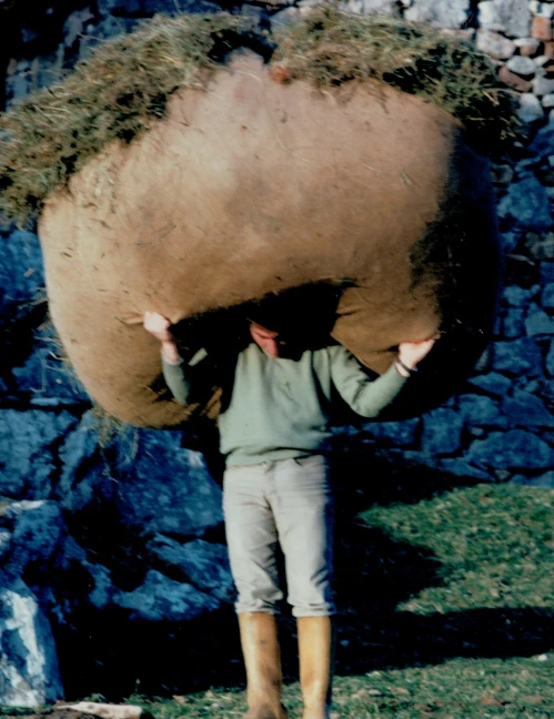 Ganadero cargando un gran fardo de hierba a la espalda en las montañas de Tresviso.